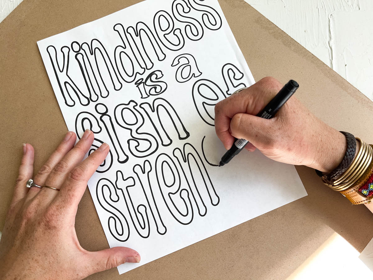 Hand lettering printable in progress that says "kindness is a sign of strength."