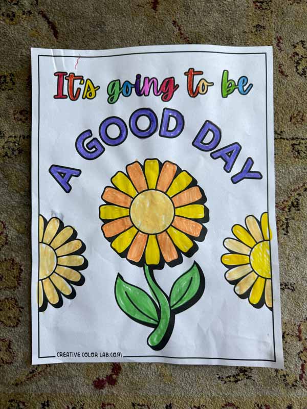 A flower with good day quote coloring page colored in.